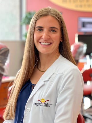 Hidden Valley Orthodontist, Dr. George, smiling in her white dental scrubs