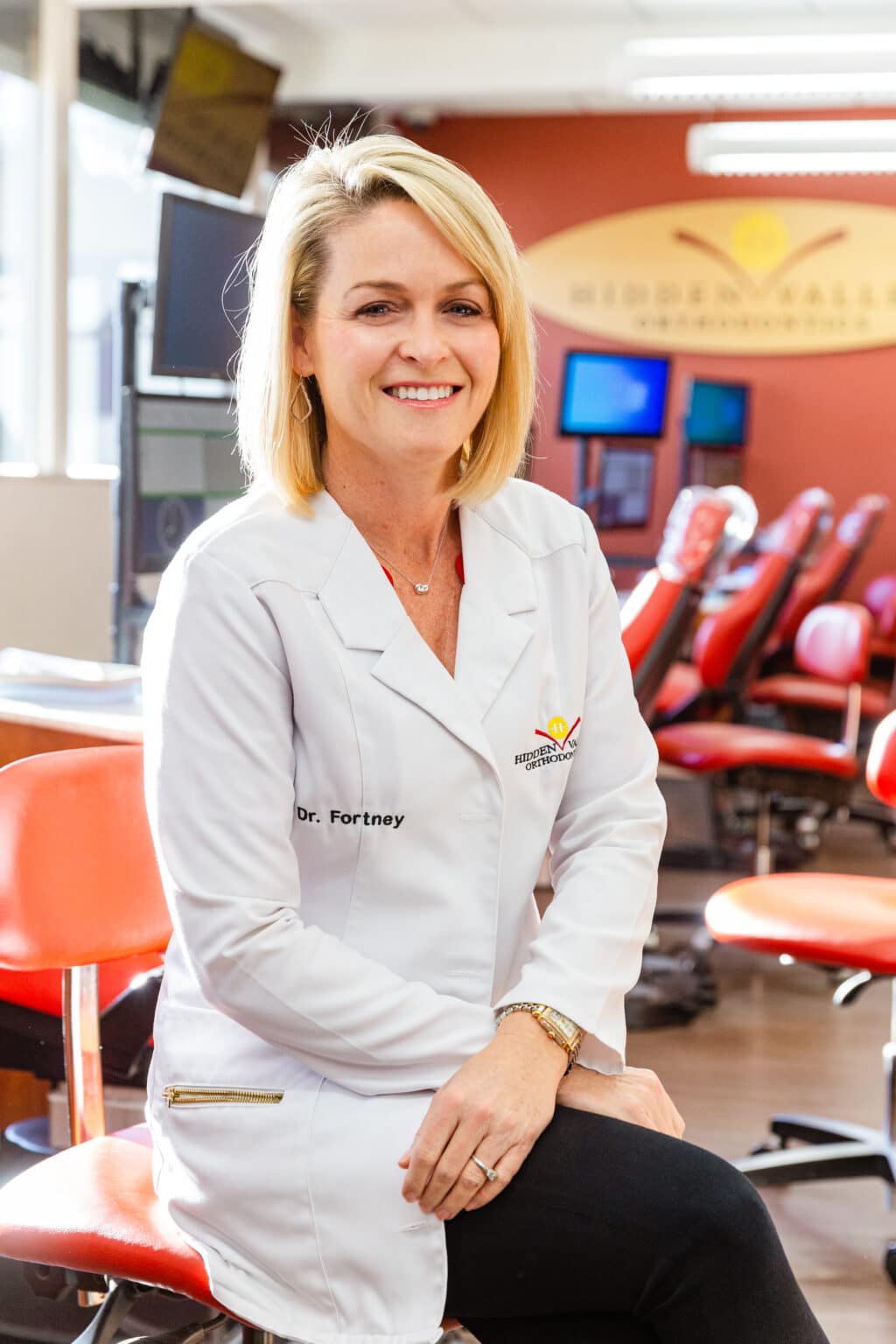 Esteemed orthodontist in Escondido and San Marcos, Dr. Fortney, smiling in her white coat