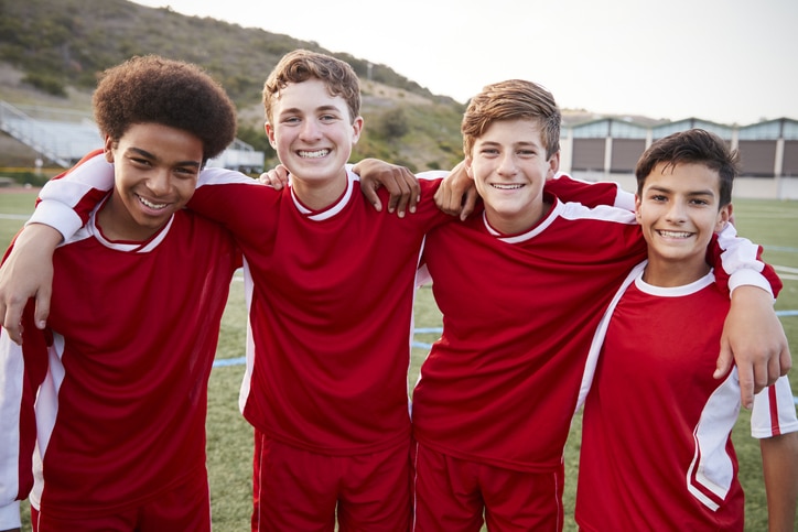 A group of boys in red soccer uniforms posing for a picture.