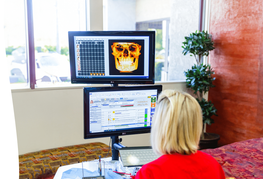 Dr. Fortney examining an x-ray in her office as the sunshine fills the room.