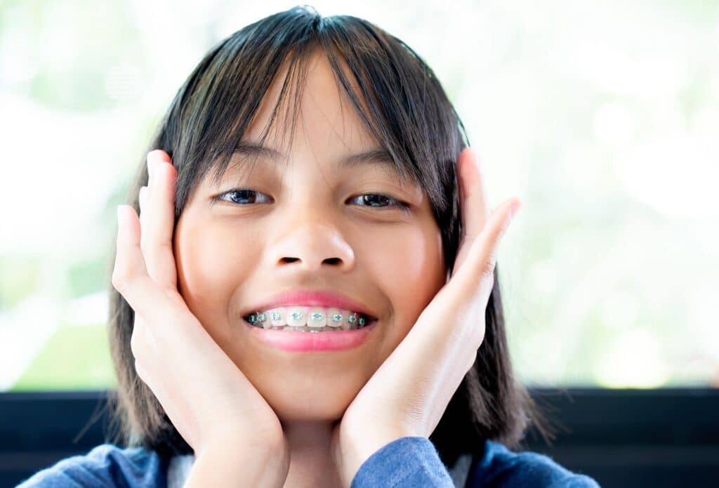 Teen with blue-green braces in San Marcos, CA from HVO smiling with her face in her hands