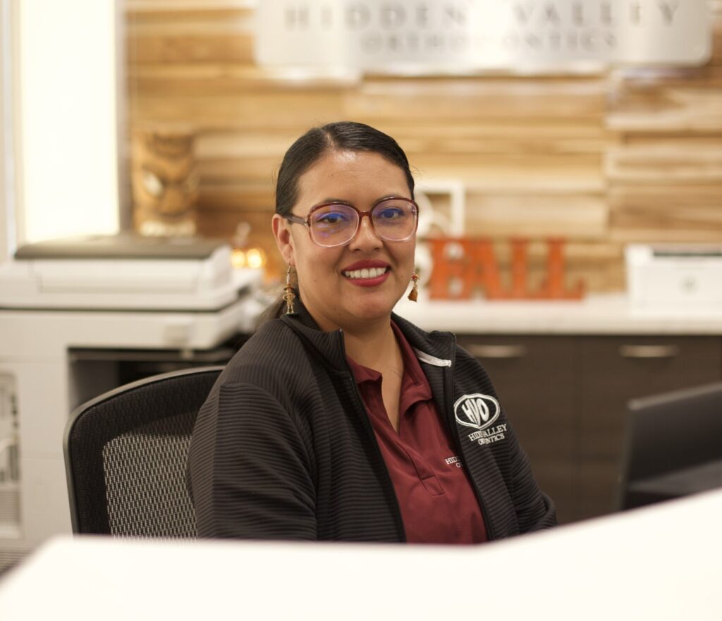 Hidden Valley Orthodontics treatment coordinator with a comforting smile in black and red