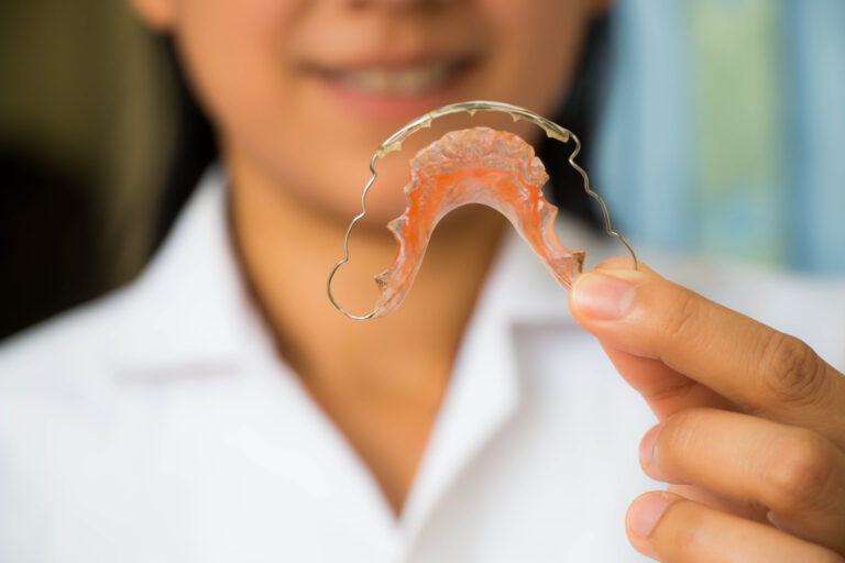 Orthodontist holding a removable metal retainer